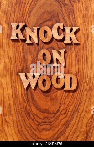 Knock On Wood phrase by wooden letters close up Stock Photo
