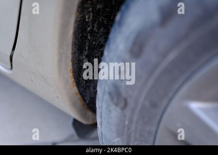 Car with rust and corrosion on the fender near the wheel. Stock Photo