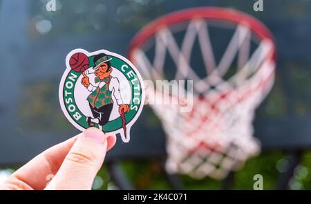 September 15, 2021, Boston, USA, A man holds the logo of the Boston Celtics basketball club in his hand on the sports field. Stock Photo