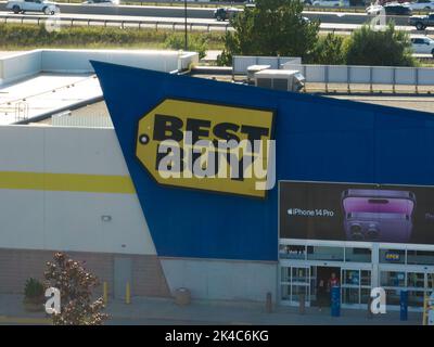 An aerial view looking at the front of a Best Buy retail store on a sunny day; an advertisement for the latest iPhone 14 Pro on the front of the store Stock Photo
