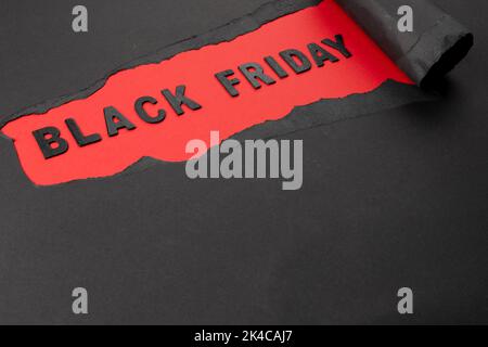 Composition of black paper and black friday text on red background Stock Photo