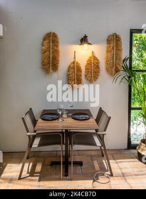 A vertical shot of a kitchen table and chairs in a holiday house with white and beige furniture interior design Stock Photo