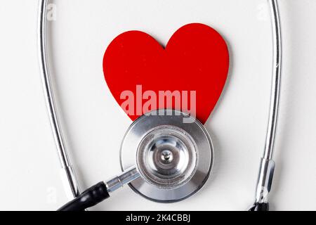 Image of red heart and stethoscope on white surface Stock Photo