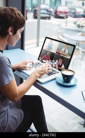 Businesswoman having a cup od coffee while using laptop in office Stock Photo