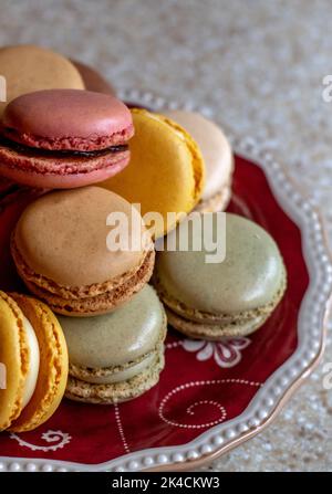 Small plate of sweet filled cookies are made from egg whites and creamy filling and called french macarons Stock Photo