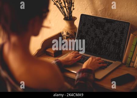 Back view of caucasian female programmer siting at desk, using laptop ...