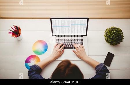 Overhead view of businesswoman using laptop at her desk Stock Photo