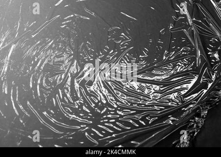 Reflecting light and shadow on creases and folds in plastic sheeting. monochrome light and texture, abstract background image. Stock Photo