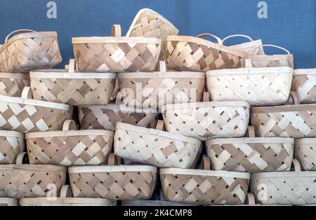 A tower of wicker baskets are piled high, for shoppers to fill with fresh fruit, veggies and fall gourds and pumpkins Stock Photo
