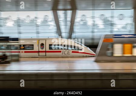 A high-speed ICE train in blur motion at the airport's long-distance station Stock Photo