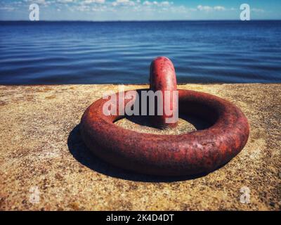 rusty metal mooring ring on concrete pier, Curonian lagoon, Lithuania Stock Photo