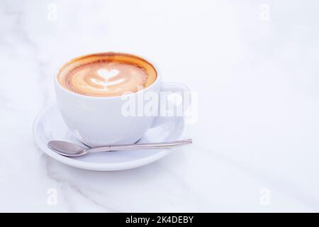 coffee latte with flower pattern in white ceramic cup food mockup bakground. Stock Photo