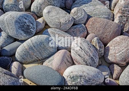 Beautiful textured coloured rocks and large stones deposited on the beach at Oldshoremore, Sutherland, Scottish Highlands, Scotland UK Stock Photo