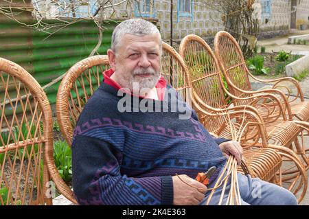 Nice portrait of ukrainian man sitting in  rocking chair he made with withe Stock Photo