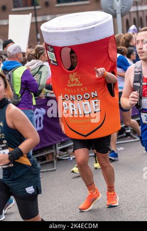 Tower Hill, London, UK. 2nd Oct, 2022. Around 50,000 people are taking part in the 2022 TCS London Marathon, including the world’s top elite runners. Athletes such as Olympic champion Kenenisa Bekele, 2021 men’s winner Ethiopian Sisay Lemma & women’s winner Kenyan Joyciline Jepkosgei are likely to feature at the front. Wheelchair athlete David Weir will also hope for a top place. The mass of club & fun runners are following with many raising large sums for charity & often running in fancy dress. 28806 Alejandro Oostlander running in London Pride pint glass of beer costume Stock Photo