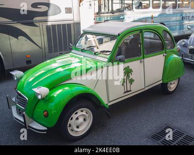 Loriol sur Drome, France - 17 September, 2022: Vintage Green Citroen 2CV with fabric hinged top and palm trees on the door. Classic car exhibition in Stock Photo