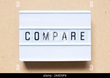 Lightbox with word compare on wood background Stock Photo