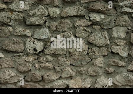 abstract grunge background: rough wall of granite stones and concrete Stock Photo