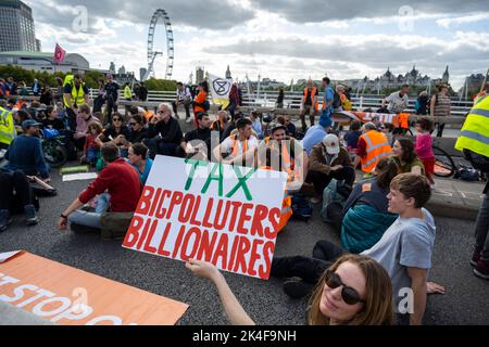 London, UK.  2 October 2022.  Environmental activists stage a sit in Just Stop Oil protest on Waterloo Bridge causing traffic held up and the bridge closed off.  Police are in attendance and requesting protesters to disperse.  Credit: Stephen Chung / Alamy Live News Stock Photo
