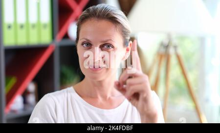 Beautiful young woman pointing finger up closeup Stock Photo