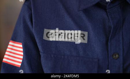 Cropped closeup of flag of United States of America on police uniform with inscription officer Stock Photo