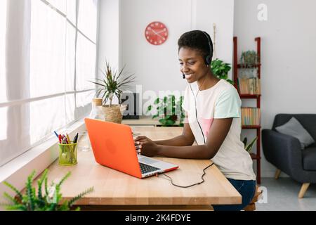 Young african woman with headset working from home office Stock Photo