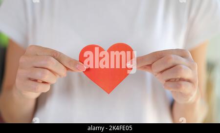 Woman holds red heart drawn on paper closeup Stock Photo