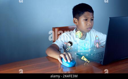 Education concept image. Creative idea and innovation. boy sitting staring at computer and there is an educational icon on the front. Stock Photo