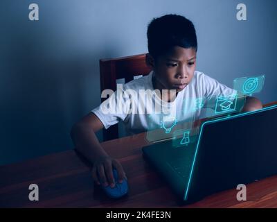 Education concept image. Creative idea and innovation. boy sitting staring at computer and there is an educational icon on the front. Stock Photo
