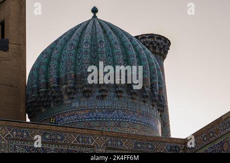 Sherdor Madrassa in Registan Complex at sunset with beautiful blue tiling on minaret and arch, Samarkand Stock Photo