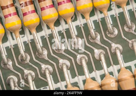 Row of carbon film resistors and soldered lead contacts on the PCB circuit board of a 1982 16k Sinclair ZX Spectrum. For electronic components. Stock Photo