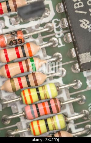 Carbon film resistors and capacitors soldered on the PCB circuit board of a 1982 16k Sinclair ZX Spectrum. For electronic components, old computers. Stock Photo
