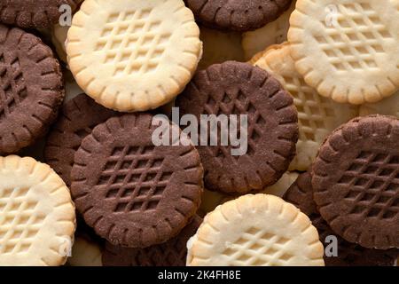 Pile of Chocolate and Vanilla Sandwhich Cookies Cut Out on White. Stock Photo