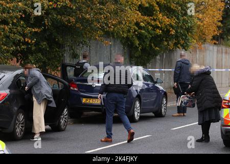 EDITORS NOTE IMAGE PIXELLATED BY THE PA PICTURE DESK FOR THE PROTECTION OF OFFICERS OF THE PSNI PSNI detectives arrive at the scene following a shooting at the clubhouse of Donegal Celtic Football Club, in west Belfast. Picture date: Sunday October 2, 2022. Stock Photo