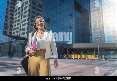 Confident, focused and powerful business woman walking in the street. Female corporate professional going or leaving the workplace after a successful Stock Photo
