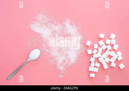 Scattered sugar and sugar cubes on a pink background, flat lay. Stock Photo