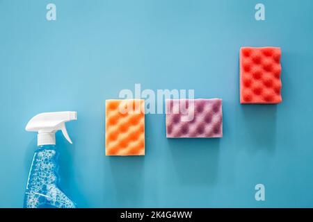 Glass cleaner spray and sponge on blue background, flat lay. Stock Photo