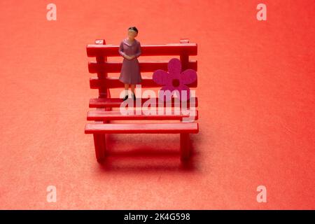 View of a man and a woman standing on a bench., symbolic photo with miniature figurines Stock Photo