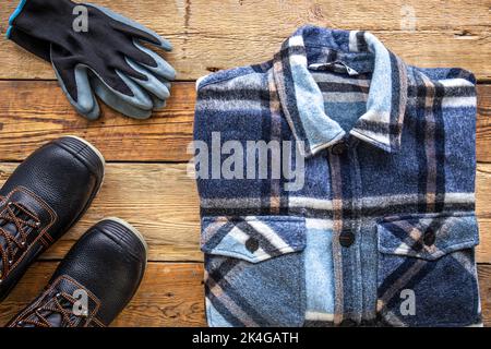 Builder uniform on wooden background, flat lay. Stock Photo