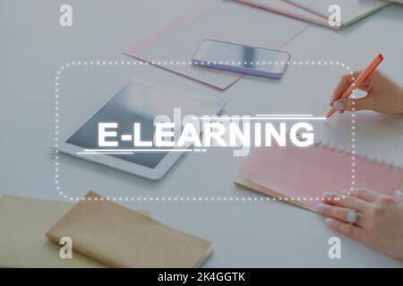 E-learning webinar. Online coaching. Remote education. Web course. Unrecognizable woman watching video lesson taking notes using tablet smartphone in Stock Photo