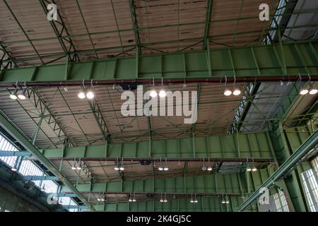 View under high ceiling of open interior space with huge steel truss, columns and beam structure building at former airport terminal in Berlin,  Germa Stock Photo