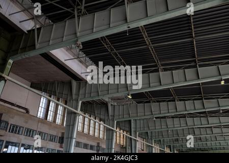 View under high ceiling of open interior space with huge steel truss, columns and beam structure building at former airport terminal in Berlin,  Germa Stock Photo