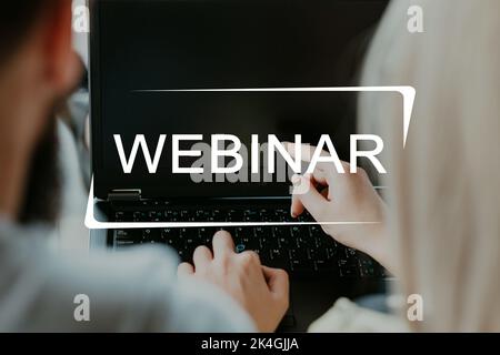 Webinar conference. Online training. Virtual education. Learning technology. Back view of unrecognizable students using laptop with text illustration. Stock Photo