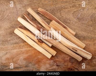 palo santo burning in front of wood background Stock Photo