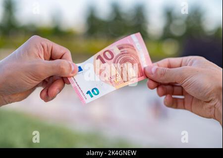 10 Euro bill passing from hand to hand Stock Photo