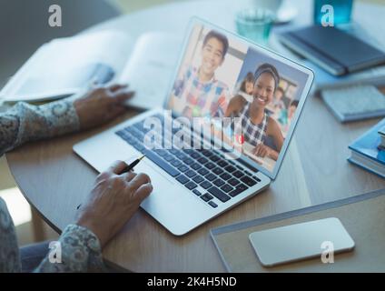 Mid section of female teacher having a video conference with male and ...