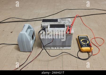 Charging a car starter battery in a garage Stock Photo