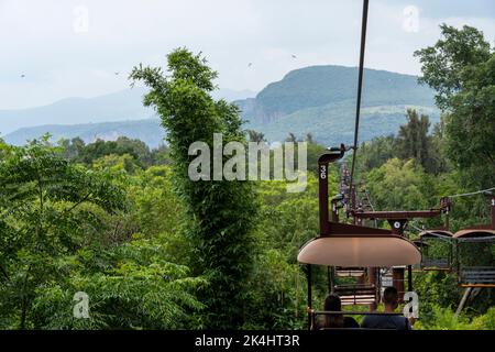 rusty old cable car, cable car ride in the rain, views of the canyon, vegetation and people. Mexico Stock Photo