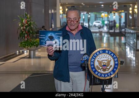 NEW YORK, NY – OCTOBER 02: Senate Majority Leader, U.S. Senator Chuck Schumer (D-NY) holds up a sign with a symbolic hacker on it on October 2, 2022 in New York City. New York Senator Chuck Schumer is calling on the federal government to release more information about recent data breaches, and to increase their efforts to protect consumers from cyber security breaches and investigate those responsible for such hacks. Credit: Ron Adar/17�Թ����� Live News Stock Photo