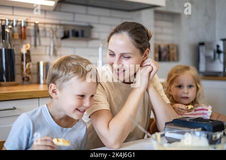 Happy family cooking baking waffles together enjoying weekend breakfast at kitchen home Stock Photo
